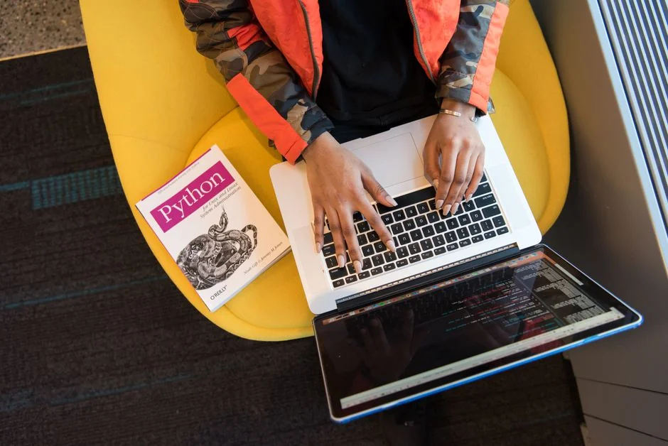 Build your dream website for your future. A laptop, MacBook, on top of a portable table with coffee tea mug on the side.